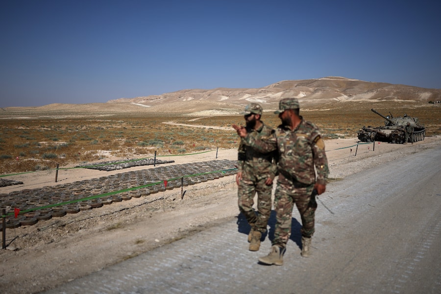 I membri di una squadra di genieri dell’esercito siriano passano accanto a mine terrestri raccolte per essere distrutte e a un veicolo da sminamento durante un’operazione di bonifica dei campi minati lasciati dalla guerra a Qara, nella campagna di Damasco, in Siria, venerdì 7 agosto 2026. (AP Photo/Ghaith Alsayed) (APN)