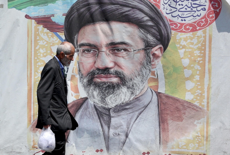 Un uomo iraniano passa davanti a un manifesto raffigurante il leader supremo iraniano, l’Ayatollah Mojtaba Khamenei, in una strada di Teheran, in Iran, il 18 giugno 2026. L’Iran e gli Stati Uniti hanno firmato un accordo di pace per porre fine alla guerra tra i due Paesi. EPA/ABEDIN TAHERKENAREH (EPA)