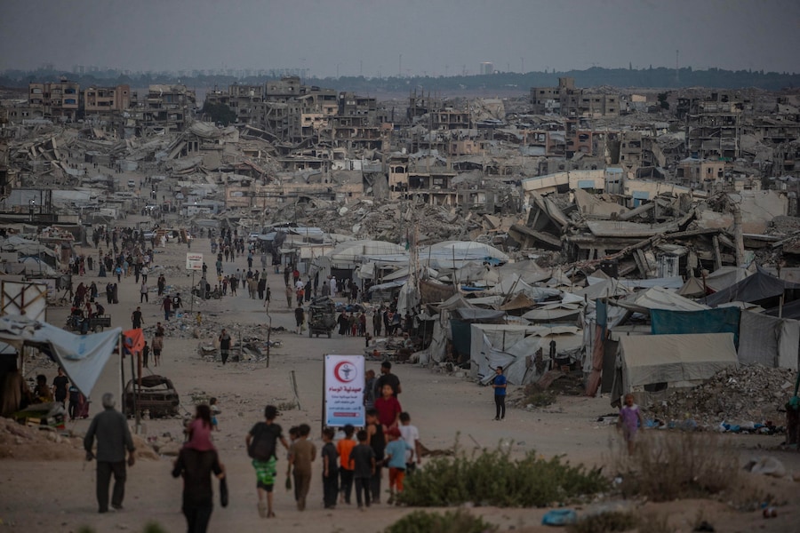 Palestinesi sfollati camminano tra le case distrutte a Jabaliya, nella zona settentrionale di Gaza City (EPA)