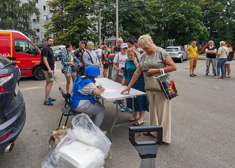 Alcuni ucraini si registrano per ricevere assistenza sul luogo di un attacco russo contro un grattacielo residenziale a Kharkiv, in Ucraina, il 9 agosto 2026, nel corso dell’invasione russa. Secondo il Servizio statale di emergenza, almeno una persona è rimasta uccisa e 27 sono rimaste ferite, tra cui un bambino, in seguito a un attacco russo a Kharkiv. EPA/SERGEY KOZLOV (EPA)