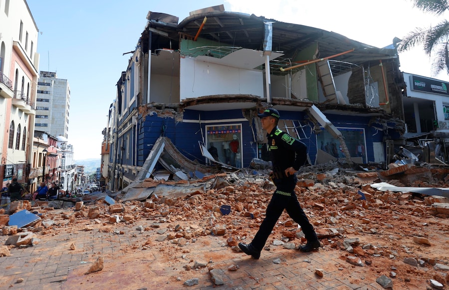 Un agente della polizia colombiana cammina davanti a un edificio danneggiato da un forte terremoto a Manizales, in Colombia, il 10 agosto 2026. (EPA)