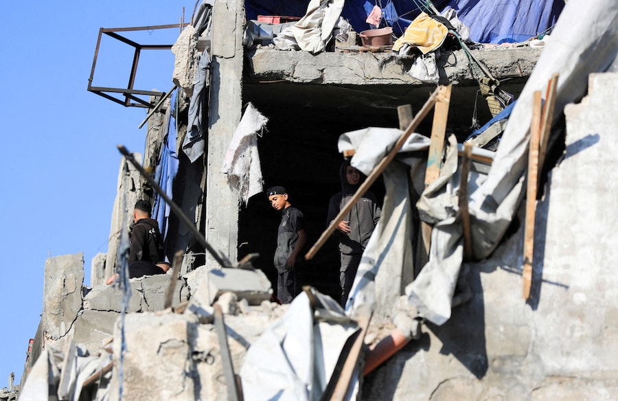 Alcuni palestinesi ispezionano i danni causati da un attacco israeliano nella città di Gaza (REUTERS)