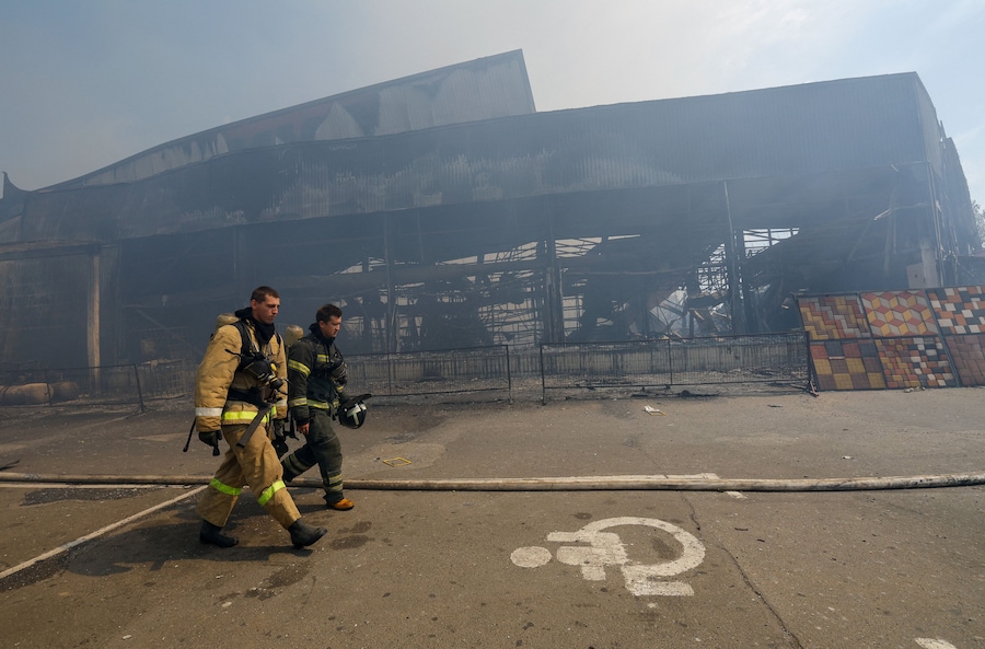 I vigili del fuoco camminano davanti a un ipermercato completamente distrutto da un incendio a seguito di un attacco avvenuto durante la notte, definito dalle autorità insediate dalla Russia come un attacco con droni ucraini, nel corso del conflitto tra Russia e Ucraina a Makiivka (Makeyevka), nella regione di Donetsk, un’area dell’Ucraina controllata dalla Russia (REUTERS)