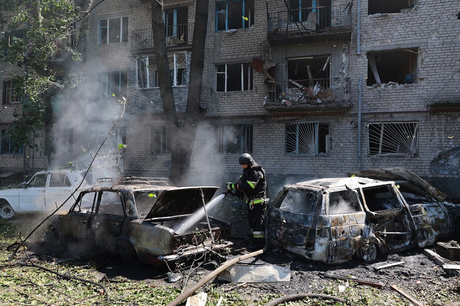 I soccorritori cercano di spegnere l'incendio divampato in un edificio residenziale e in alcune auto a seguito di un attacco aereo russo con bombe guidate a Zaporizhzhia, in Ucraina (APN)