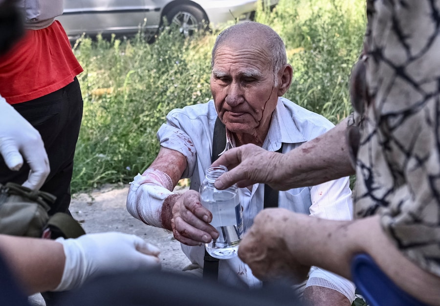 Un residente ferito prende una bottiglia d’acqua sul luogo di un condominio colpito da un attacco aereo russo a Zaporizhzhia, Ucraina (REUTERS)