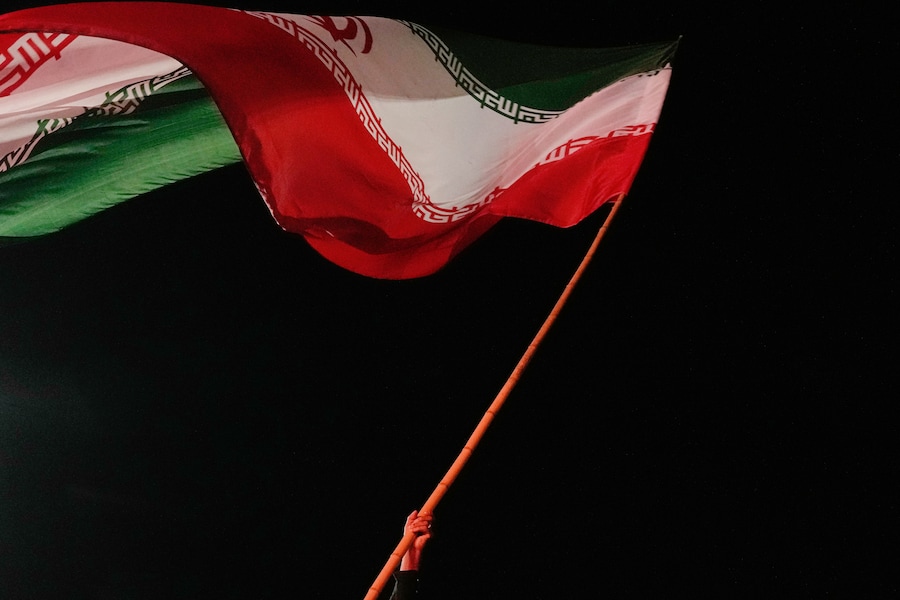 Un uomo sventola una bandiera iraniana durante una manifestazione filogovernativa in una piazza di Teheran, in Iran (APN)