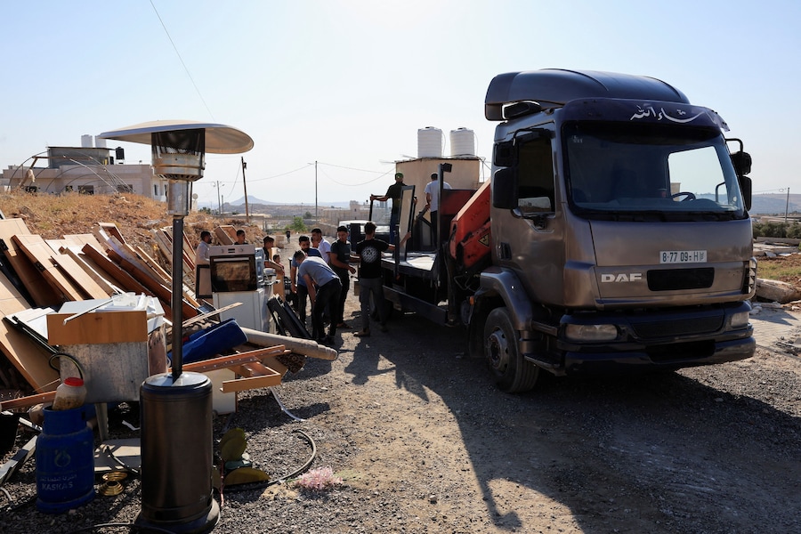 Alcune persone sono al lavoro nei pressi del luogo del danno dopo che dei mezzi pesanti israeliani hanno demolito un edificio palestinese vicino a Betlemme, nella Cisgiordania occupata da Israele (REUTERS)