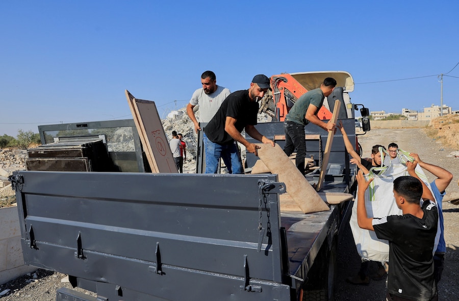 Alcune persone sono al lavoro nei pressi del luogo del danno dopo che dei mezzi pesanti israeliani hanno demolito un edificio palestinese vicino a Betlemme, nella Cisgiordania occupata da Israele (REUTERS)