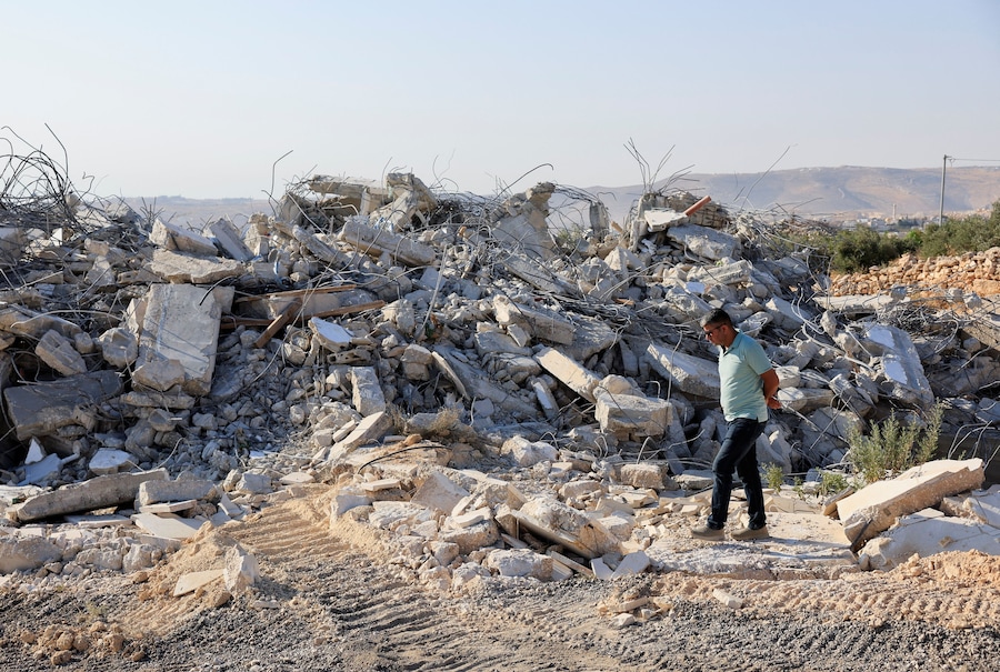 Un uomo verifica i danni dopo che alcuni mezzi pesanti israeliani hanno demolito un edificio palestinese nei pressi di Betlemme, nella Cisgiordania occupata da Israele (REUTERS)