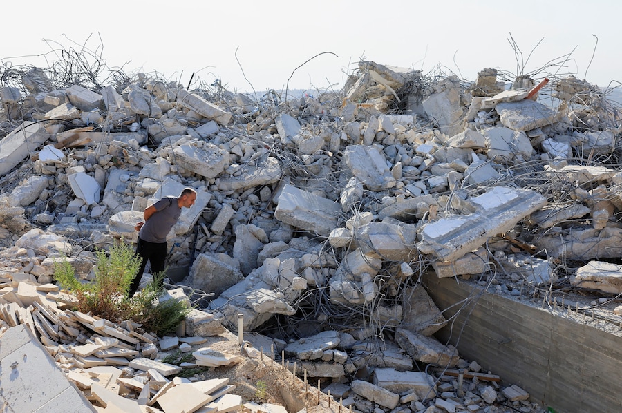 Un uomo verifica i danni dopo che alcuni mezzi pesanti israeliani hanno demolito un edificio palestinese nei pressi di Betlemme, nella Cisgiordania occupata da Israele (REUTERS)