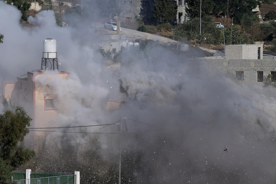 Il fumo si alza mentre l’esercito israeliano fa esplodere degli ordigni nell’abitazione del palestinese ucciso Farouq Ramadan nel villaggio di Tell, vicino alla città di Nablus in Cisgiordania (EPA)