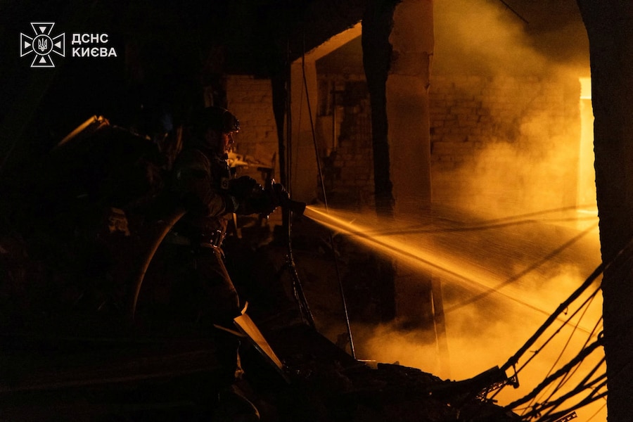 Un vigile del fuoco è al lavoro nel complesso di un magazzino colpito da un attacco missilistico avvenuto durante la notte a Kiev, Ucraina (via REUTERS)