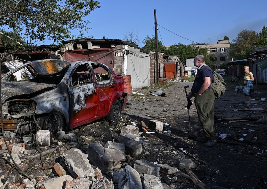 Un residente osserva un'auto danneggiata sul luogo di un condominio colpito da un attacco aereo russo a Zaporizhzhia, Ucraina (REUTERS)