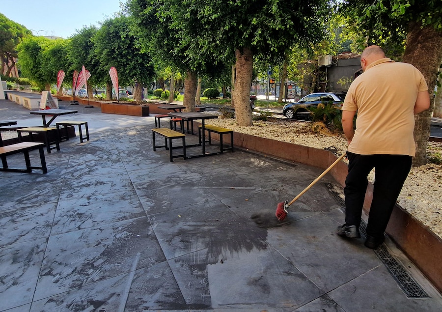 Commercianti al lavoro per ripulire dall'abbondante ricaduta di cenere provocata dall'attività dell'Etna che ha investito anche Catania. ANSA/ORIETTA SCARDINO (ANSA)
