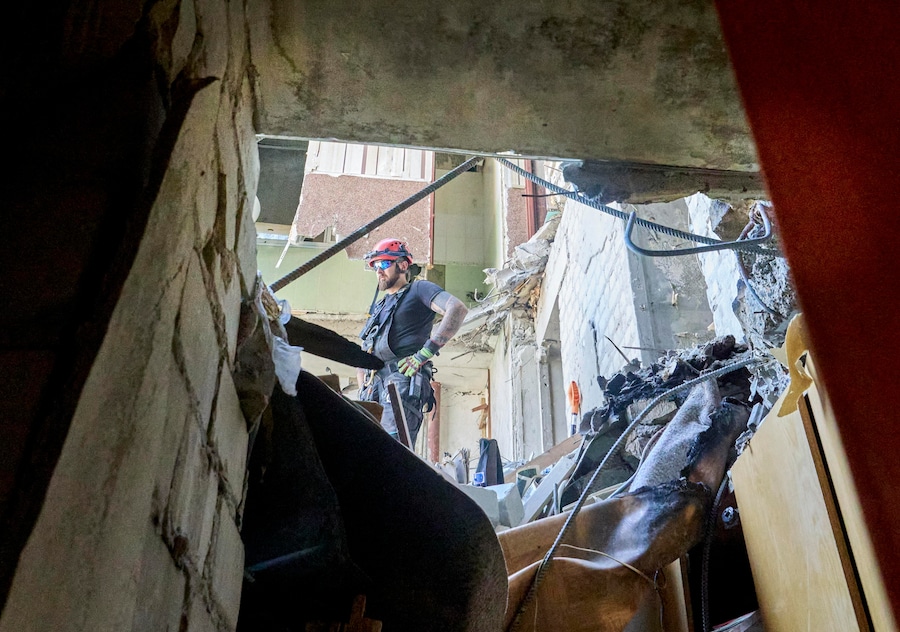 I soccorritori ucraini continuano a rimuovere le macerie sul luogo di un attacco russo contro un grattacielo residenziale nel centro di Kharkiv (EPA)
