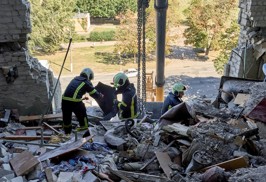 I soccorritori ucraini continuano a rimuovere le macerie sul luogo di un attacco russo contro un grattacielo residenziale nel centro di Kharkiv (EPA)