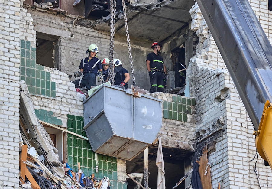 I soccorritori ucraini continuano a rimuovere le macerie sul luogo di un attacco russo contro un grattacielo residenziale nel centro di Kharkiv (EPA)
