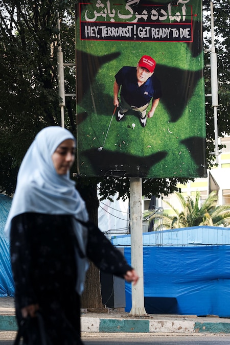 Una persona cammina vicino a uno striscione che raffigura il presidente degli Stati Uniti Donald Trump mentre gioca a golf, in una strada di Teheran, in Iran, il 13 agosto 2026. Majid Asgaripour/WANA (West Asia News Agency) via REUTERS (via REUTERS)