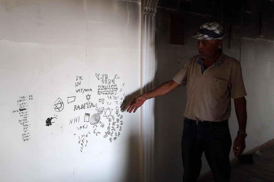 Un uomo indica una scritta in ebraico su una parete all’interno della sua abitazione nel villaggio di Zawtar al-Gharbiya, nel sud del Libano, il 13 agosto 2026. Zawtar al-Gharbiya è una delle zone pilota designate nell’ambito dell’accordo di cessate il fuoco tra Libano e Israele, da cui le forze israeliane si sono ritirate. EPA/WAEL HAMZEH (EPA)