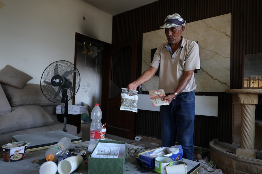 Un uomo trasporta sacchi di frutta secca utilizzati dai soldati dell’esercito israeliano all’interno della sua abitazione nel villaggio di Zawtar al-Gharbiya, nel Libano meridionale, il 13 agosto 2026. Zawtar al-Gharbiya è una delle zone pilota designate nell’ambito dell’accordo di cessate il fuoco tra Libano e Israele, da cui le forze israeliane si sono ritirate. EPA/WAEL HAMZEH (EPA)