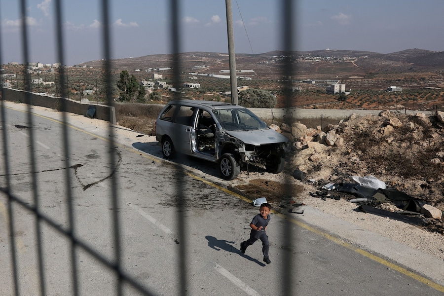 Un bambino palestinese gioca per strada alla periferia di Qusra, un villaggio palestinese nella Cisgiordania occupata da Israele, il 14 agosto 2026. (REUTERS)