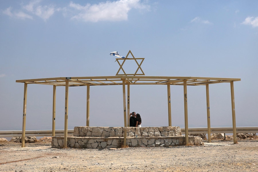 Una coppia israeliana si scatta un selfie mentre si bacia su un belvedere affacciato sulla Valle del Giordano, nei pressi del villaggio di Majdal Bani Fadil in Cisgiordania, il 14 agosto 2026. (EPA)