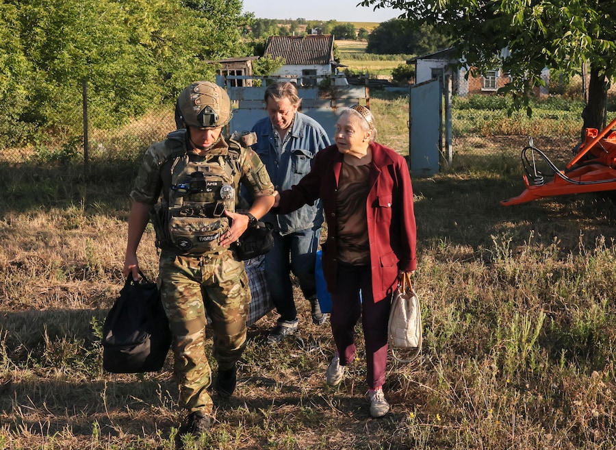 Un soldato ucraino aiuta alcune persone anziane mentre agenti di polizia ucraini e volontari dell’organizzazione pubblica “Chaplain Patrol” evacuano gli anziani dagli insediamenti in prima linea nella regione di Zaporizhzhia, nel sud-est dell’Ucraina, il 14 agosto 2026. (EPA)