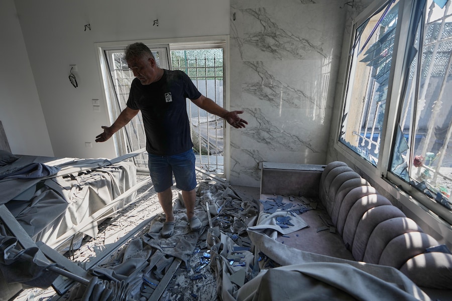 Un uomo ispeziona la sua camera da letto danneggiata dopo che un attacco aereo israeliano ha colpito e distrutto un'abitazione nel villaggio di Ansar, nel Libano meridionale. (APN)