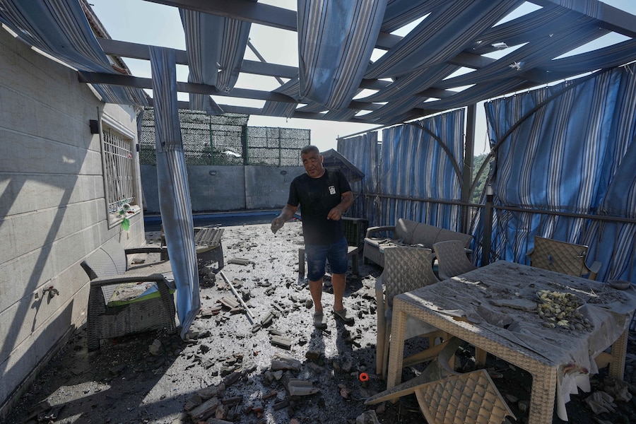 Un uomo ispeziona la sua terrazza danneggiata da un attacco aereo israeliano ha colpito e distrutto un'abitazione nel villaggio di Ansar, nel Libano meridionale. (APN)