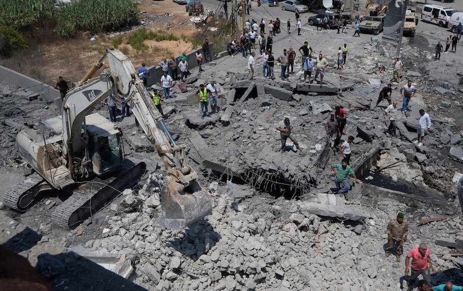 Cittadini e soccorritori sul luogo di una casa distrutta, colpita da un attacco aereo israeliano nel villaggio di Deir al-Zahrani, nel sud del Libano. (APN)