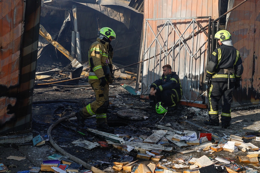 I vigili del fuoco si concedono una breve pausa mentre operano sul luogo di un mercatino dei libri colpito da un missile russo, nel contesto dell'attacco della Russia all'Ucraina, a Kiev, Ucraina, il 16 agosto 2026. (REUTERS)