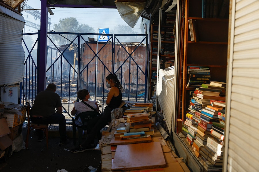 Dipendenti seduti accanto ai libri nel loro negozio, situato all'interno di un complesso di un mercato librario danneggiato da un attacco missilistico russoa Kiev, Ucraina, il 16 agosto 2026. (REUTERS)