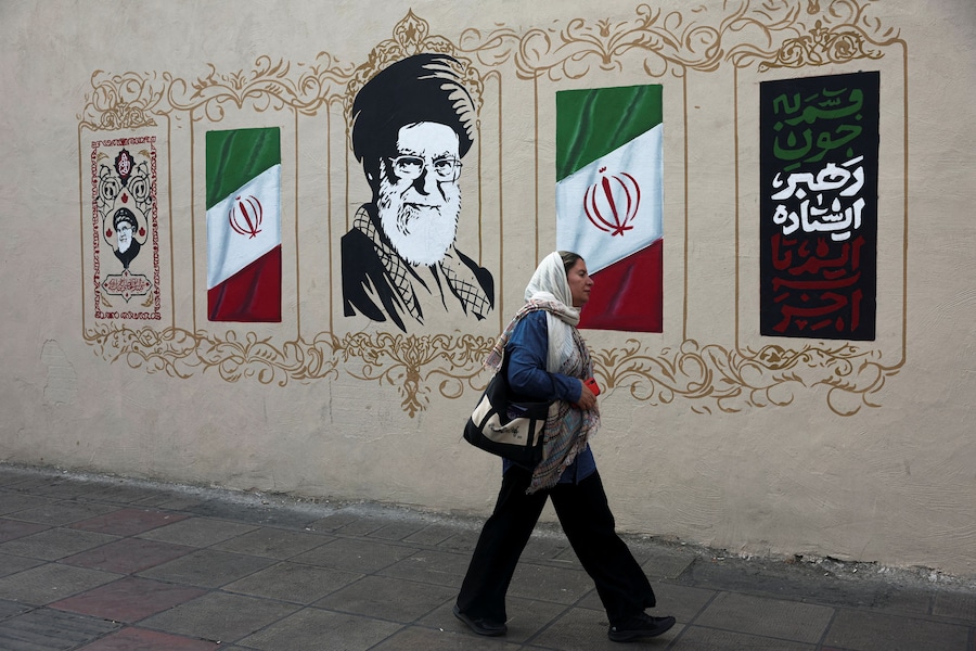 Una donna passa davanti a un murale raffigurante il defunto leader supremo iraniano, l'ayatollah Ali Khamenei, in una strada di Teheran, in Iran. (Majid Asgaripour/WANA (West Asia News Agency) via REUTERS)