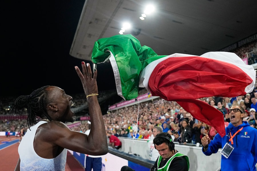 Andy Diaz Hernandez, medaglia d'oro, afferra una bandiera per festeggiare dopo la finale del salto triplo maschile. (APS)