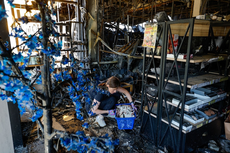 Un venditore raccoglie prodotti cosmetici all'interno di un ipermercato distrutto da un incendio in seguito a un attacco notturno sferrato da droni ucraini, nel corso del conflitto tra Russia e Ucraina a Donetsk, città ucraina sotto il controllo russo. (REUTERS)