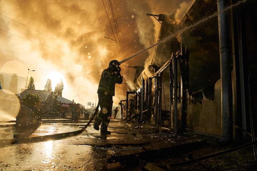 I vigili del fuoco cercano di spegnere un incendio divampato in un mercatino dei libri della città a seguito di un attacco missilistico russo a Kiev, in Ucraina. (APS)