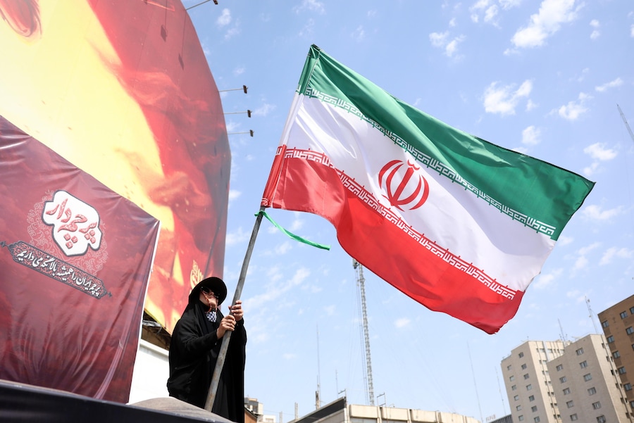 Una donna iraniana sventola la bandiera nazionale iraniana in piazza Valiasr a Teheran. (EPA/Abedin Taherkenareh)