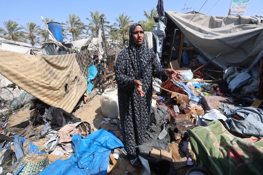 Una donna palestinese vicino a una tenda danneggiata da un attacco israeliano, a Khan Younis, nella Striscia di Gaza meridionale. (REUTERS/Ramadan Abed)
