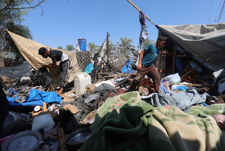 I palestinesi ispezionano il luogo in cui, secondo i soccorritori, si è verificato un attacco israeliano contro una tenda a Khan Younis, nella parte meridionale della Striscia di Gaza. (REUTERS/Ramadan Abed)