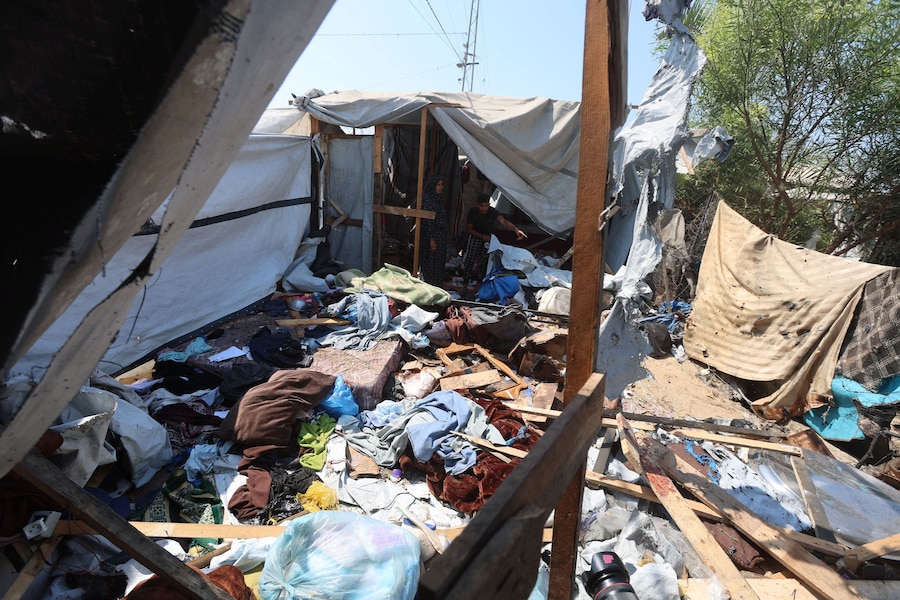 I palestinesi ispezionano il luogo in cui, secondo i soccorritori, un attacco israeliano ha colpito una tenda a Khan Younis, nella parte meridionale della Striscia di Gaza. (REUTERS/Ramadan Abed)