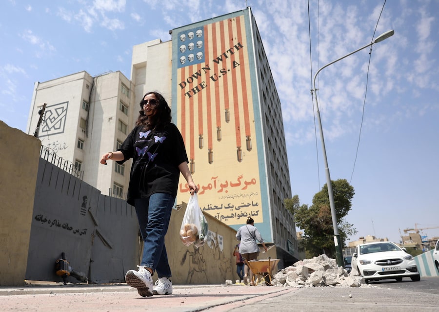 Una donna iraniana passa davanti a un murale anti-statunitense a Teheran. Il capo dell'esercito iraniano Amir Hatami ha annunciato una taglia di 30.000 dollari statunitensi per l'uccisione o la cattura di militari statunitensi, offrendo il doppio della ricompensa alle donne iraniane che compiano tale azione, secondo quanto riportato dai media statali iraniani. (EPA/Abedin Taherkenareh)