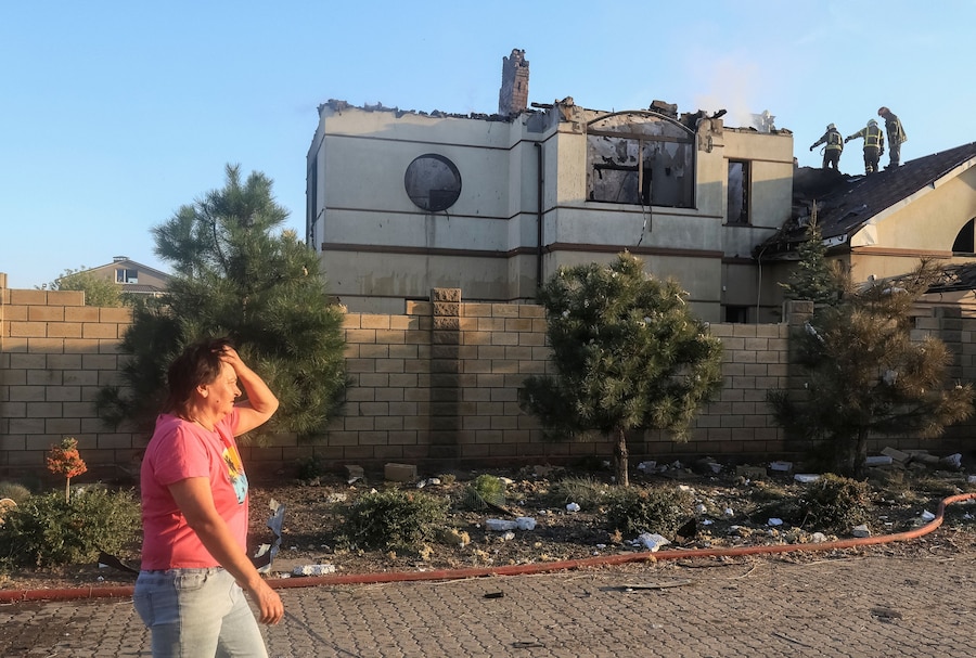 Una donna reagisce mentre cammina nei pressi di un'abitazione privata danneggiata durante un attacco russo con missili e droni, nel contesto dell'offensiva russa contro l'Ucraina, nella città di Chornomorsk, nella regione di Odessa, Ucraina. (REUTERS)