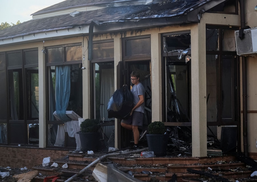 Un abitante raccoglie oggetti da un'abitazione privata danneggiata durante un attacco russo con missili e droni, nel contesto dell'offensiva russa contro l'Ucraina, nella città di Chornomorsk, nella regione di Odessa. (REUTERS)