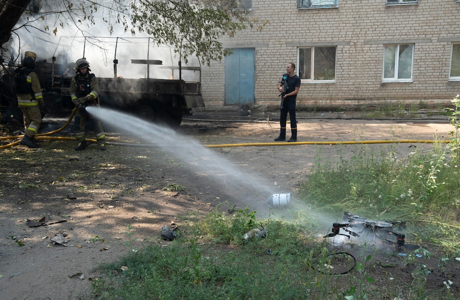 I soccorritori ucraini rimuovono i detriti del drone FPV abbattuto nei pressi del luogo in cui un recente attacco russo con un drone FPV in fibra ottica ha provocato l'incendio di due auto, a Sloviansk, nella regione di Donetsk. (EPA)