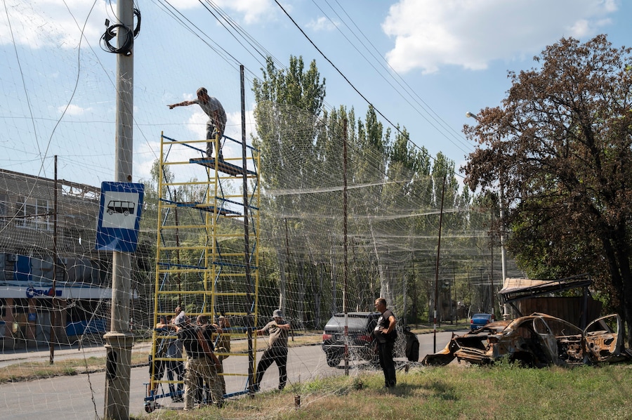 Militari ucraini del 1221° Battaglione di supporto autonomo riparano le reti anti-drone danneggiate dai recenti attacchi russi, che hanno visto l’impiego di numerose bombe aeree guidate KAB, contro una struttura a Sloviansk, nella regione di Donetsk. (EPA)