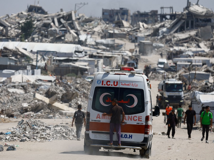Una persona è in piedi sul retro di un'ambulanza in un luogo devastato durante l'offensiva israeliana, a Beit Lahiya, nella parte settentrionale della Striscia di Gaza. (REUTERS/Mahmoud Issa)