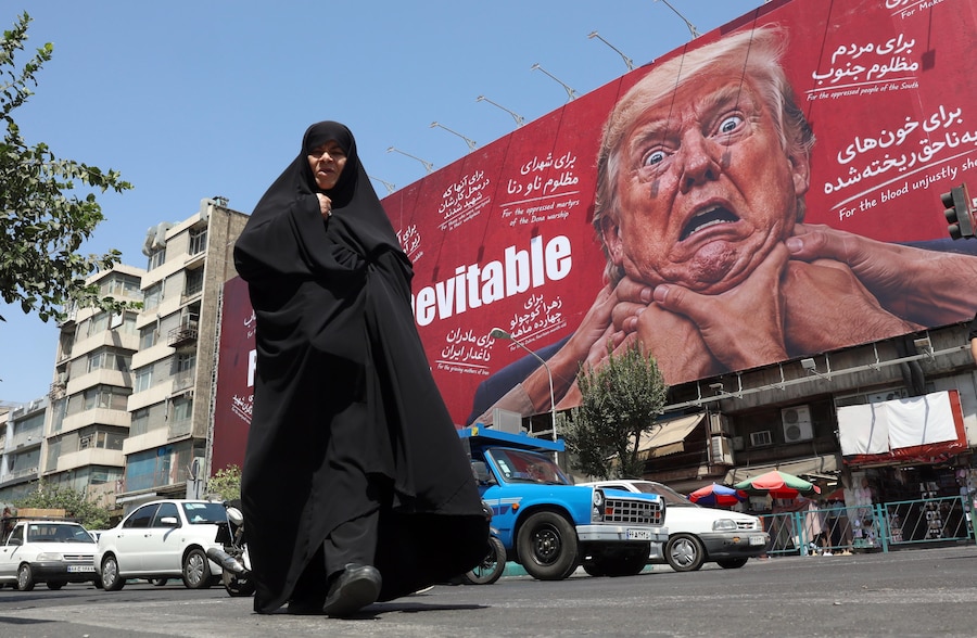 Una donna cammina accanto a un cartellone pubblicitario contro Trump a Teheran, in Iran. Il presidente del Parlamento iraniano Mohammad Bagher Ghalibaf ha affermato che lo Stretto di Hormuz rimarrà chiuso fino a quando gli Stati Uniti non revocheranno il blocco e non porranno fine alle sanzioni. (EPA/Abedin Taherkenareh)