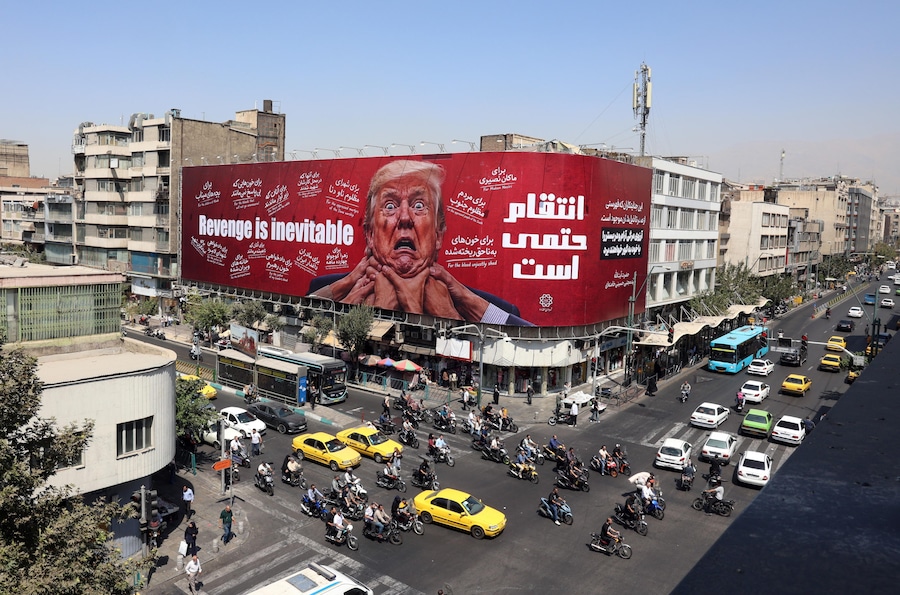 Alcuni iraniani passano in auto davanti a un cartellone pubblicitario contro Trump a Teheran. Il presidente del Parlamento iraniano Mohammad Bagher Ghalibaf ha affermato che lo Stretto di Hormuz rimarrà chiuso finché gli Stati Uniti non revoca il blocco e non pone fine alle sanzioni. (EPA/Abedin Taherkenareh)