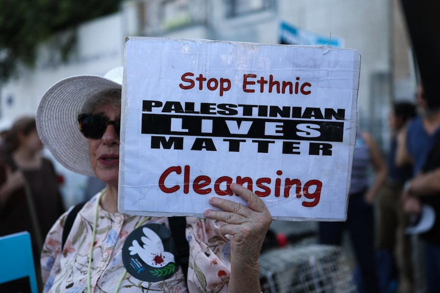 Attivisti israeliani espongono striscioni durante una manifestazione di protesta contro l'escalation di violenza da parte dei coloni nei confronti dei palestinesi in Cisgiordania, nei pressi della residenza del presidente israeliano a Gerusalemme. (EPA/Atef Safadi)