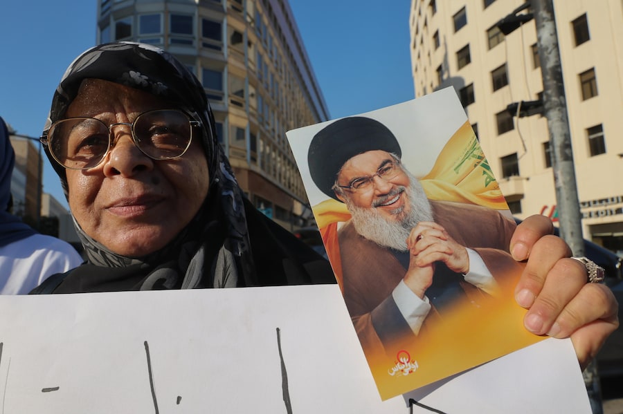Una donna tiene in mano una foto del defunto leader di Hezbollah Nasrallah mentre i sostenitori di Hezbollah manifestano davanti al Palazzo del Governo libanese a Beirut, in Libano, per opporsi ai colloqui diretti tra Libano e Israele. (EPA/Wael Hamzeh)